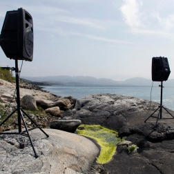 Photograph: Speakers playing music in landscape. Stokkøya, Norway.